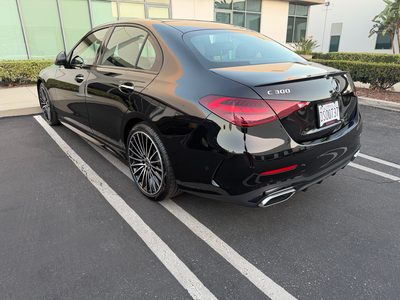 Black Mercedes-Benz C300, opposite rear three-quarter view